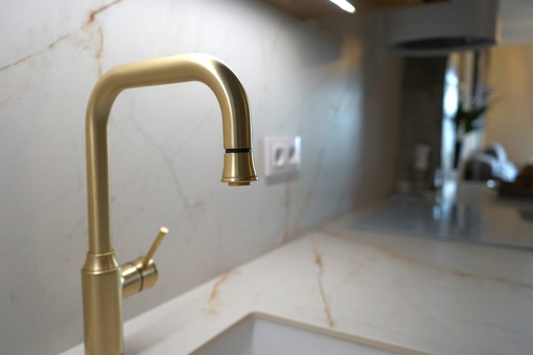 Detalles dorados cocina verde y madera