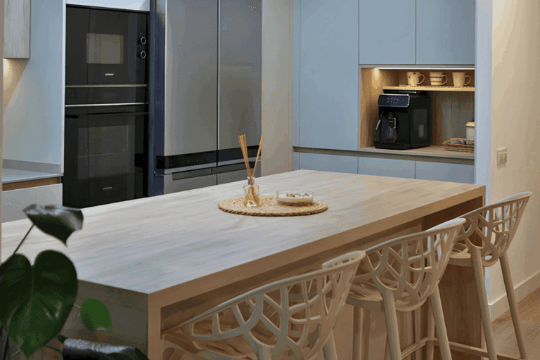Cocina de diseño abierta al salón con acabados en madera y piedra.