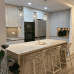 Cocina abierta al salón con isla central y mobiliario fabricado a medida.