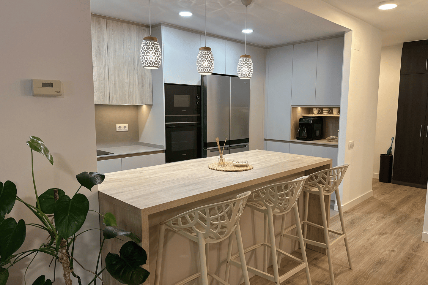 Cocina abierta al salón con isla central y mobiliario fabricado a medida.