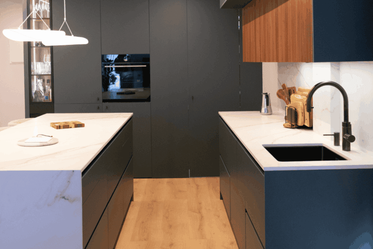 Columnas de cocina verdes con electrodomésticos integrados y armarios hasta el techo.