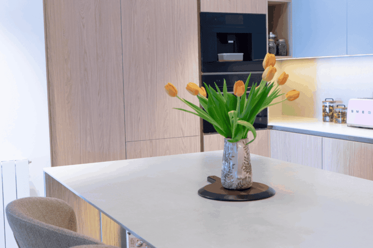 Detalle de una cocina moderna con iluminación integrada y acabados elegantes.